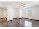 A bedroom featuring dark hardwood floors, a ceiling fan and a window with blinds at 6697 Boom Town Dr, Las Vegas, NV 89122