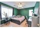 Cozy bedroom with a large window, wood floors, and painted green walls at 6891 Nickel Mine Ave, Las Vegas, NV 89122