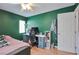 Bedroom with laminate wood flooring and painted green walls and a modern ceiling fan at 6891 Nickel Mine Ave, Las Vegas, NV 89122