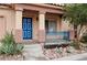 Close up of a front porch featuring decorative pillars, desert rock landscaping, and a blue front door at 6891 Nickel Mine Ave, Las Vegas, NV 89122