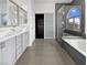 Modern bathroom featuring a double vanity, a bathtub, and a glass-enclosed shower with gray tiles at 7110 Brighton Village St, Las Vegas, NV 89166