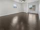 An unfurnished bedroom featuring dark wood floors, white walls, natural light, and a closet at 7110 Brighton Village St, Las Vegas, NV 89166