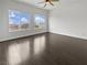 Bright bedroom featuring hardwood floors, white walls and trim, and two large windows providing natural light at 7110 Brighton Village St, Las Vegas, NV 89166