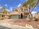 Charming two-story stucco home featuring a well-maintained yard, two-car garage, and inviting curb appeal at 7110 Brighton Village St, Las Vegas, NV 89166