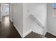Hallway featuring hardwood floors, white walls and trim, and a staircase with a white handrail at 7110 Brighton Village St, Las Vegas, NV 89166