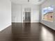 Bright living room featuring hardwood floors, white walls and trim, and a view into another room at 7110 Brighton Village St, Las Vegas, NV 89166
