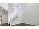 Bright foyer with a white staircase and a two-story wall with a window at the top at 7110 Brighton Village St, Las Vegas, NV 89166
