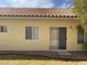 Home's backyard with tile roof, tan exterior, sliding door, and lawn at 7456 Oatman Ln, Las Vegas, NV 89120