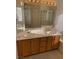 Double vanity bathroom with a large mirror and neutral cabinets at 7456 Oatman Ln, Las Vegas, NV 89120