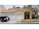 Charming single-story home featuring a two-car garage and a well-maintained front yard with mature tree at 7456 Oatman Ln, Las Vegas, NV 89120