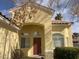 Close-up of a single-story home with a classic red front door and manicured bushes at 7456 Oatman Ln, Las Vegas, NV 89120