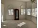 Bright living room featuring large windows, neutral carpet and a decorative cabinet at 7456 Oatman Ln, Las Vegas, NV 89120