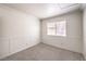 Cozy bedroom with carpet flooring, wainscoting, and a window offering natural light at 7613 Falconwing Ave, Las Vegas, NV 89131