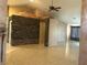 Open living area with tile floors, stone accent wall, and large windows at 7613 Falconwing Ave, Las Vegas, NV 89131