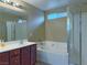 Bathroom featuring a large soaking tub, glass-enclosed shower, and double vanity at 7735 Pista Way, Las Vegas, NV 89179