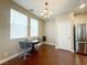 Bright dining area featuring a modern chandelier, wood floors, and large windows at 7735 Pista Way, Las Vegas, NV 89179