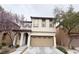 Charming two-story home featuring a tan stucco facade, a 2-car garage, and a red tile roof at 7735 Pista Way, Las Vegas, NV 89179