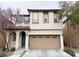 Charming two-story home with a tan stucco exterior, a two-car garage, and blossoming trees at 7735 Pista Way, Las Vegas, NV 89179