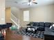 Comfortable living room with a black sectional, a staircase, and hardwood floors at 7735 Pista Way, Las Vegas, NV 89179