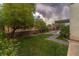 Lush backyard with grass, plants, brick accents, and covered patio at 780 Flowing Meadow Dr, Henderson, NV 89014