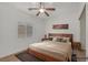 Bedroom featuring a decorative wood frame bed, ceiling fan, window, and wood-look flooring at 780 Flowing Meadow Dr, Henderson, NV 89014