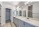 Bright bathroom with a double sink vanity, a large mirror, and a glass-enclosed shower, with wood-look flooring at 8629 Ensworth St # 111, Las Vegas, NV 89123
