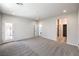 Open bedroom featuring neutral carpet, a glass patio door, and doorways to a closet and ensuite bathroom at 8629 Ensworth St # 111, Las Vegas, NV 89123