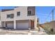 Contemporary two-story home with a gray garage door and red front door, landscaped with desert plants at 8629 Ensworth St # 111, Las Vegas, NV 89123