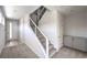 Bright foyer with carpeted stairs and metal handrails, featuring gray built-in cabinetry and a white front door at 8629 Ensworth St # 111, Las Vegas, NV 89123