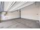 An empty two car garage with concrete floors, white walls, and a standard garage door at 8629 Ensworth St # 111, Las Vegas, NV 89123