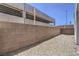 View of the gravel backyard, enclosed by a tall brick wall, offering privacy at 8629 Ensworth St # 112, Las Vegas, NV 89123