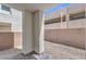 A small gravel backyard is surrounded by a brick wall and the building's exterior at 8629 Ensworth St # 112, Las Vegas, NV 89123