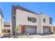 Newly built home with modern architecture, gray garage doors, and a vibrant red front door at 8629 Ensworth St # 112, Las Vegas, NV 89123