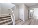 Hallway with stairs, modern railing, and wood-look flooring, leading into an open kitchen area at 8629 Ensworth St # 112, Las Vegas, NV 89123