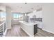 Open kitchen featuring island, white cabinets, pendant lighting, and durable wood-look flooring at 8629 Ensworth St # 112, Las Vegas, NV 89123