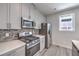 Modern kitchen features stainless steel appliances, stone countertops, and stylish gray cabinetry at 8629 Ensworth St # 112, Las Vegas, NV 89123