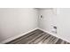 A bright laundry room features wood-style flooring and white walls, with connections for a washer and dryer at 8629 Ensworth St # 112, Las Vegas, NV 89123