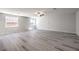 Spacious living room with light-colored wood floors, multiple windows, and a ceiling fan at 8629 Ensworth St # 112, Las Vegas, NV 89123