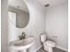 Chic powder room featuring a pedestal sink, round mirror, and modern fixtures at 8629 Ensworth St # 112, Las Vegas, NV 89123