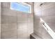 Modern shower featuring sleek tile walls, built in bench, and natural light from a horizontal window at 8629 Ensworth St # 112, Las Vegas, NV 89123