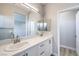 Elegant bathroom with a double sink vanity, large framed mirror, and a view into the walk-in shower at 8629 Ensworth St # 113, Las Vegas, NV 89123