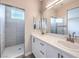 Modern bathroom with double vanity, a framed mirror, and a tiled shower with a glass door at 8629 Ensworth St # 113, Las Vegas, NV 89123