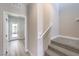 Hallway with light wood-look flooring and carpeted stairs with a door leading to the back yard at 8629 Ensworth St # 113, Las Vegas, NV 89123