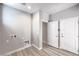 Bright laundry room with white walls, tile floors, and utility hookups, located between two white interior doors at 8629 Ensworth St # 113, Las Vegas, NV 89123