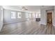 Expansive living space with light wood-look floors flowing into an open-concept kitchen and half bathroom at 8629 Ensworth St # 113, Las Vegas, NV 89123