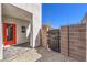 Exterior view of backyard entrance, with brick wall accent and red door at 8629 Ensworth St # 114, Las Vegas, NV 89123