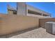 An empty backyard with decorative rocks, an AC unit, and a wall to create a private space at 8629 Ensworth St # 114, Las Vegas, NV 89123