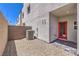 A low-maintenance backyard with decorative rocks, AC unit, and a red entry door at 8629 Ensworth St # 114, Las Vegas, NV 89123