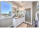 Bright bathroom featuring double sinks, a large window, and a glass enclosed shower at 8629 Ensworth St # 114, Las Vegas, NV 89123