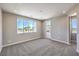 Bright, spacious bedroom with large windows and neutral carpet, door leading to outside at 8629 Ensworth St # 114, Las Vegas, NV 89123